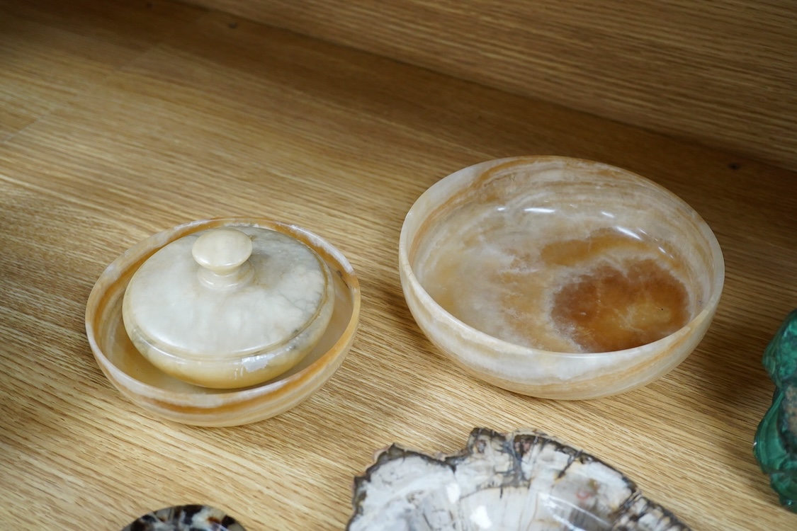 Two petrified wood ashtrays, a malachite rock, three onyx bowls, one with cover, and one other item, larger ashtray 17.5cm wide